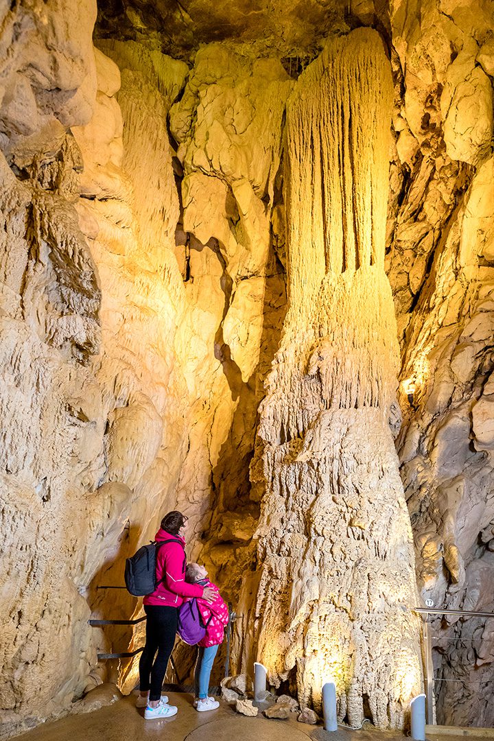 Visiteurs observant une colonne dans les Grottes de Vallorbe